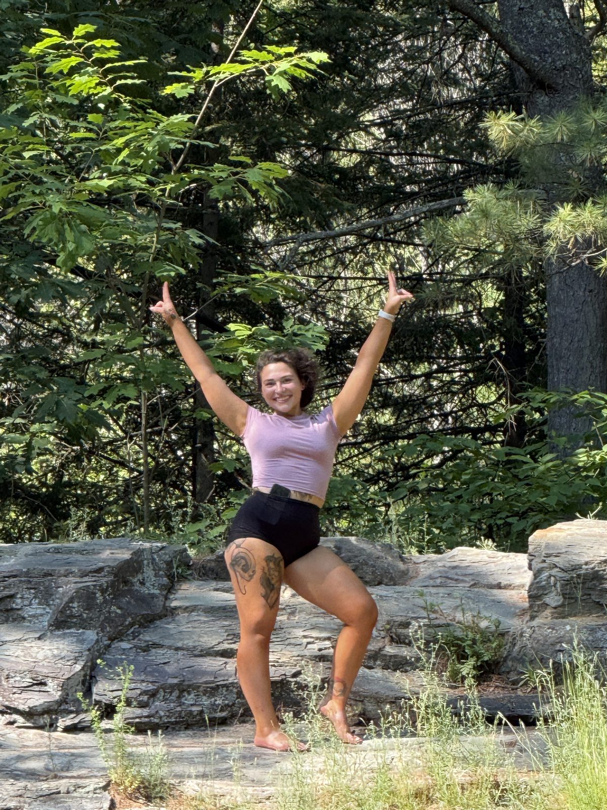 Lexy celebrating outdoors on a rocky trail
